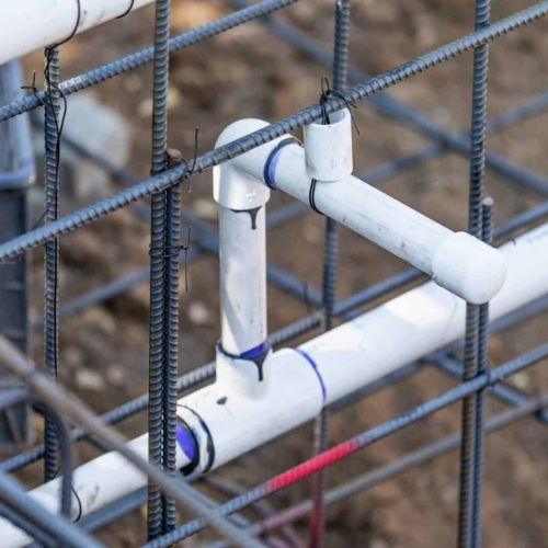 Newly Installed PVC Plumbing Pipes and Steel Rebar Configuration At Construction Site